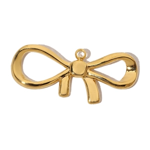 Detailed close-up of a golden metal bow-shaped pendant with a polished finish