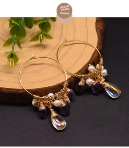 Detail of handmade bohemian earrings with pearls and iridescent water drop pendants