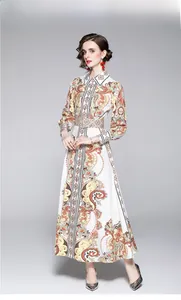 Détails d'une robe blanche à manches longues avec imprimés paisley, col et ceinture