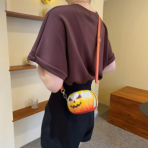 Detailed back view of a pumpkin-shaped crossbody bag with a jack-o'-lantern smiley face