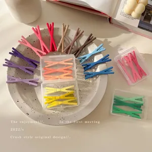 Colorful matte X-shaped hair clips in pastel macaron colors set on a stylish ceramic plate