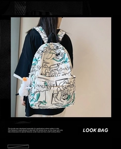 Detail view of graffiti print waterproof backpack with cute plush duck pendant on side