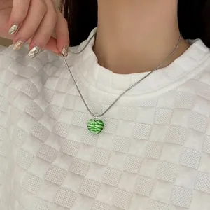 Fashionable green zebra pattern heart necklace with silver chain on model neck