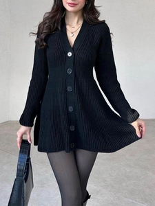Détail d'une robe en tricot noire pour femme avec col en V et texture à rayures verticales