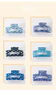 Detailed grid view of six assorted blue evil eye pattern hair claws with glossy finish
