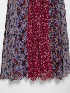 Dettaglio del tessuto in chiffon plissettato a fiori colorati con motivi rossi e viola