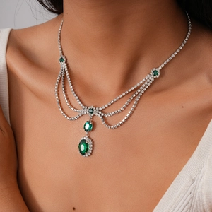 Close-up of luxury multi-layer emerald pendant necklace with sparkling diamonds on model