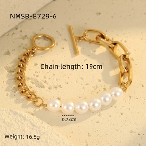 Detalle de una pulsera de cadena vintage dorada con perlas y cierre de barra en piedra