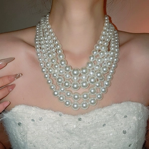 Close-up of elegant multi-layer white pearl necklace worn by a model in French style