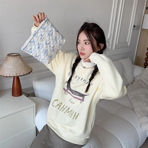 Close-up of quilted floral teddy bear cosmetic bag and beige sweatshirt with dog print