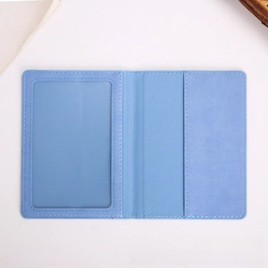 Flat lay of light blue leather passport cover with clear ID window and card slots