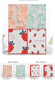 Detail of floral and strawberry cartoon paper gift bags with silver rope handles