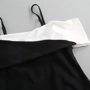 Detail of V-neck one-piece swimsuit featuring black and white contrast stitching and straps
