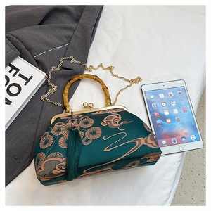 Details der grünen Satintasche mit Goldstickerei, Bambusgriff und goldener Metallkette
