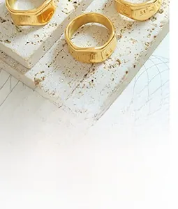 Detail view of irregular hammered gold-plated rings with textured surface on stone