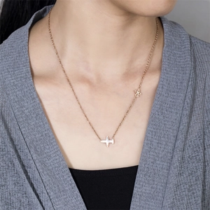 Modèle portant un collier en or rose avec des pendentifs avion en nacre et ajourés