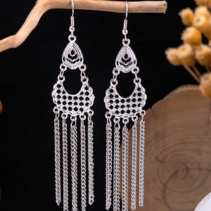 Detailed view of silver bohemian tassel earrings featuring intricate floral cutouts and chains