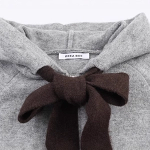 Women's gray knit hoodie featuring a stylish brown ribbon bow and soft textured fabric