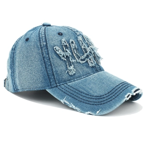 Détail macro de la casquette baseball en denim bleu délavé avec patch lettre NYC vintage