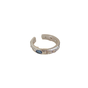 Silver geometric textured ring with blue zircon stones on a white background