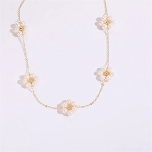 Detailed view of freshwater pearl flower charm on a 14K gold plated dainty necklace
