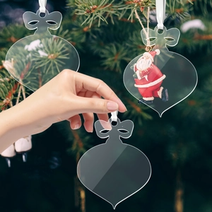 Close-up of clear acrylic Christmas tree hanging ornaments with bows on a festive tree