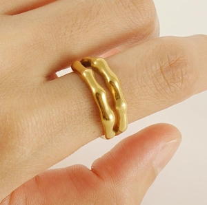 Nahaufnahme eines zweischichtigen goldenen Bambus-Rings, getragen in Alltagsszene