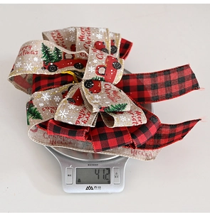 Close-up showing a 41.2g Christmas plaid truck bow being measured on a digital scale