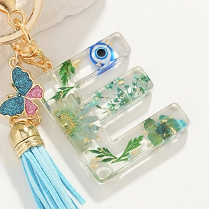 Resin letter E keychain with dried flowers, evil eye, butterfly and blue tassel charm