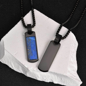 Close-up of black rectangular stone pendant with blue lapis lazuli on stone block
