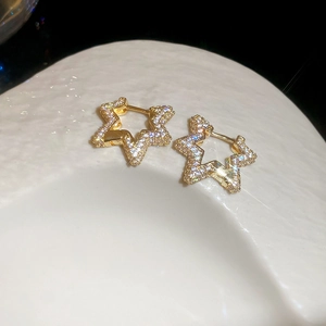 Detailed close-up of golden star hoop earrings with pavé set cubic zirconia crystals