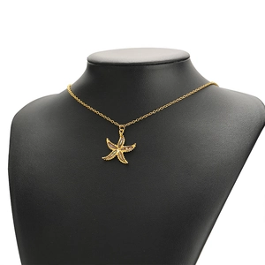 Golden starfish necklace with abalone shell inlay on black mannequin bust for display