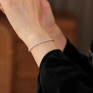 Close-up of minimalist silver beaded bracelet with polished metallic finish on wrist