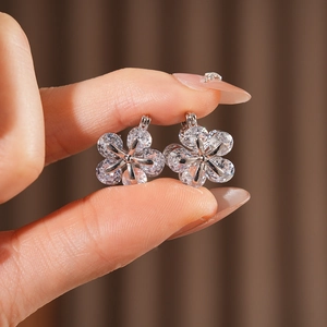 Gros plan de boucles d'oreilles fleur en zircon étincelant avec pétales argentés