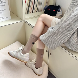 Detail of khaki cotton socks with heart embroidery and Follow Your Heart text