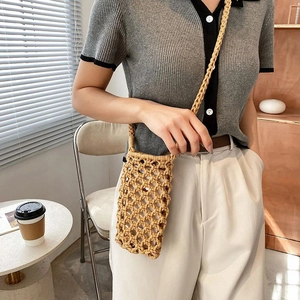 Detail of hand-woven mesh pattern and shoulder strap on the khaki cotton phone bag