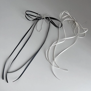 Detailed view of handmade bow hair clips with long ribbons and beaded accents