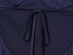 Detail of the elegant satin dress showing navy blue bow-tie design and stitching