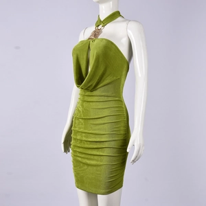 Détail de la robe courte verte froncée montrant l'anneau doré et la texture brillante