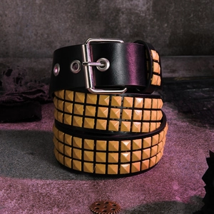 Close-up of triple-row yellow pyramid studs on black punk rocker Y2K leather belt