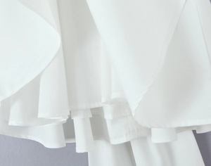 Detail of layered white chiffon ruffles and hemline on a feminine puff dress