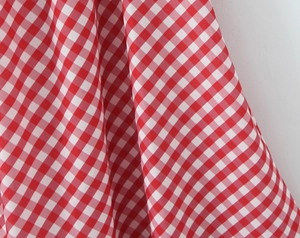 Vue macro détaillée de la texture du tissu vichy rouge et blanc et des plis de la matière