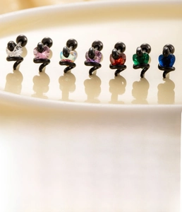 Macro shot of colorful heart zircon cartilage studs with black titanium steel screws