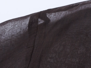 Macro detail of high-quality chiffon fabric stitching and sheer mesh shoulder texture