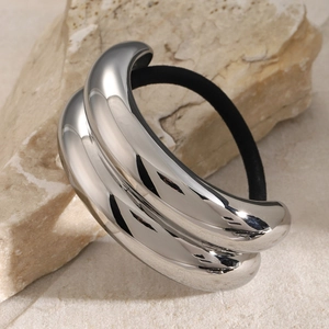 Close-up of polished silver metal hair tie with high-elastic black rubber band on stone
