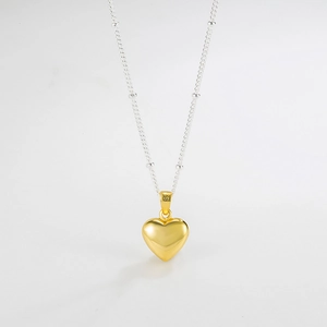 Detail of gold heart pendant with S925 hallmark on a beaded silver chain necklace