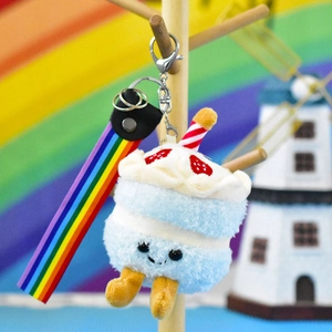 Close-up of blue cake plush keychain with vibrant rainbow strap and smiley face details.