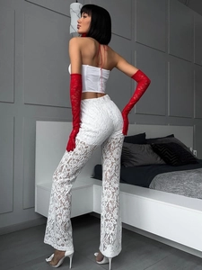 Sexy weiße Schlaghose aus Spitze mit hoher Taille und roten Handschuhen im Schlafzimmer