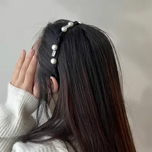 Elegant knotted black headband with white pearls and rectangular crystals on model's hair