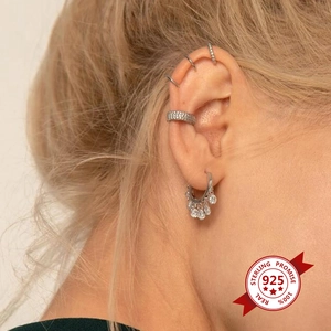 Macro detail of 925 sterling silver hoop earrings with micro-set zircon on model ear